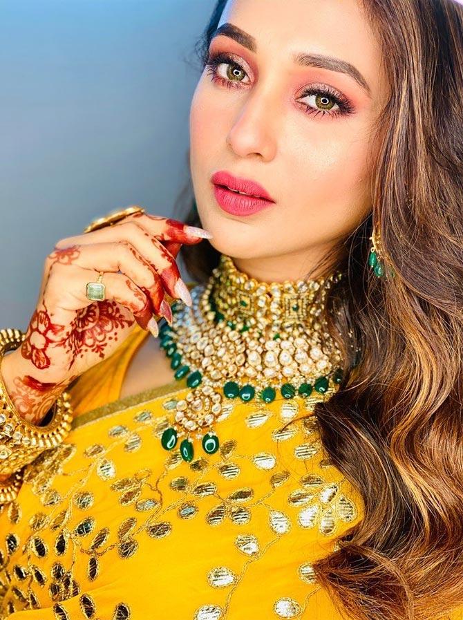 For a wedding event, Mimi stunned in this bright yellow saree with silverwork. Her loud makeup, mehendi and heavy jewellery makes her look even more confindent.