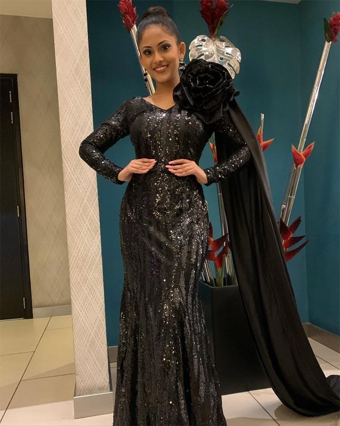 In this photo, she dons a black embellished gown with her hair tied in a bun and a long trail attached to her gown. 