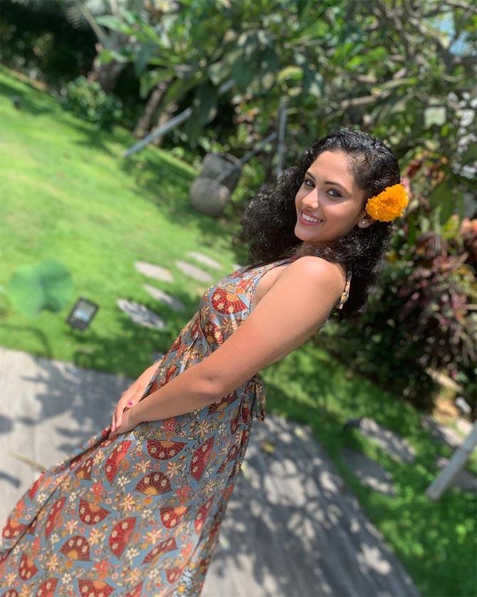 She defines herself as a happy soul, as she rocks a summer dress with flowers in her hair. 