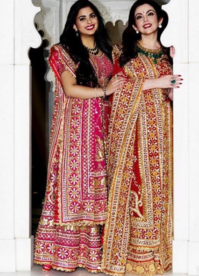 Now that we know that the mother-daughter duo often appreciate the designers' work, here they are seen together in gota-patti lehengas. Their ensembles have multiple borders on the ghagra and dupatta featuring beautiful floral bael motifs. Nita's ghagra is finished with a peacock Zardozi border, while Isha's ensemble displays the radiance of a real gold Kuran lace border.