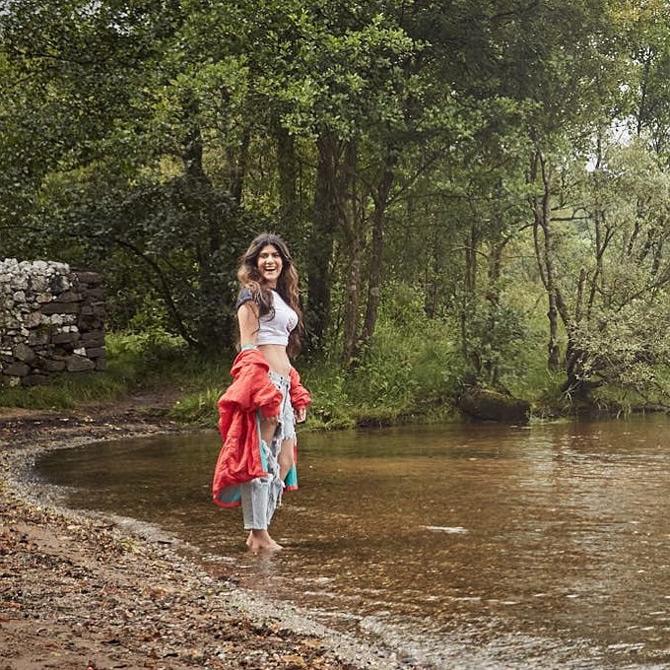 In photo: Ananya Birla caught in a light moment as she enjoys the beauty of nature while donning a white crop top with a pair of denim and red jacket.