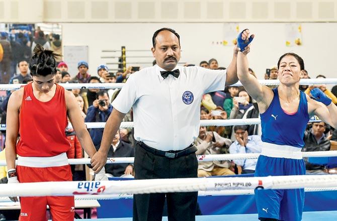 The referee declares MC Mary Kom (right) the winner as Nikhat Zareen hangs her head in disappointment 