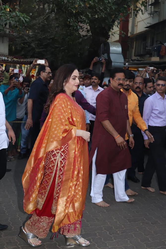 Nita Ambani completed her look with an orange colour silk dupatta and silver heels. The mother of the soon-to-be-groom wore pretty diamond earrings to compliment her outfit