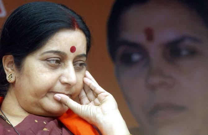 Sushma Swaraj appeared to be in a pensive mood during an ongoing week-long protest rally for fireband Hindu nun and former chief minister of Madhya Pradesh state Uma Bharti (photograph in the background) in Bangalore, September 5, 2004. Swaraj along with BJP leader and former union ministers Arun Jaitley and Maneka Gandhi and senior party leader Vinay Katiyar (unseen) were arrested after addressing a BJP rally to protest against the arrest of Bharti after an Indian court had issued an arrest warrant in her name for defying a curfew in 1994 and attempting to hoist India's national flag at the Idgah Maidan, a prayer ground in Hubli that is disputed by Hindus and Muslims