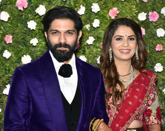 For their gala reception, Amit Thackeray's wife Mitali Borude wore a stunning pink-coloured Sabyasachi lehenga and paired it with a red dupatta. To complement her look, Mitali wore glass and gold bangles. On the other hand, Amit Thackeray looked suave in a purple-black three-piece suit
