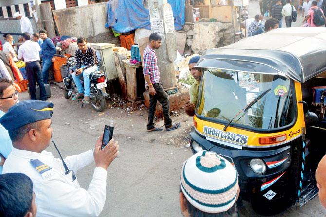 A traffic cop films the licence plate number of an errant auto driver at Kurla railway station