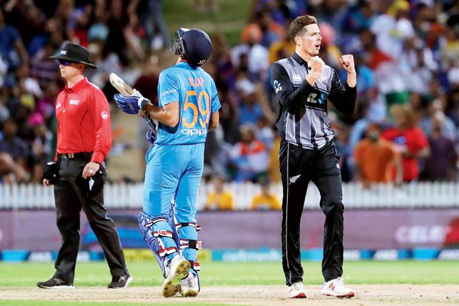 NZ spinner Mitchell Santner (right) celebrates the dismissal of India