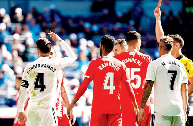 Real Madrid captain Sergio Ramos (left) is shown the red card after picking a second yellow against Girona yesterday. Pics/AFP
