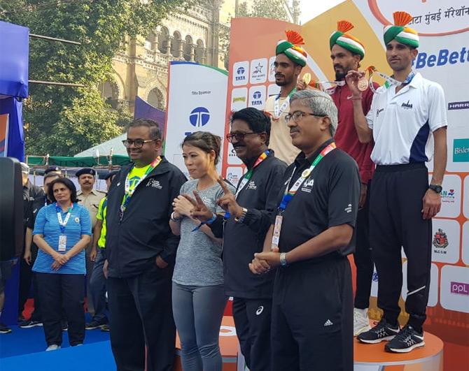 MC Mary Kom, the brand ambassador of the Tata Mumbai Marathon poses for a picture after presenting the winners' medals to the Indian runners who won the Indian elite men's category. Narendra Singh Rawat cracked a timing of 2:15.52 while T Gopi finished second with a timing of 2:17:03. Karan Singh came third with a timing of 2:20:10. Pic credit/ Twitter IOS India