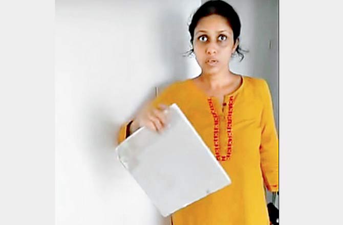 Home owner Shilpi Thard holds up a fragment of her house