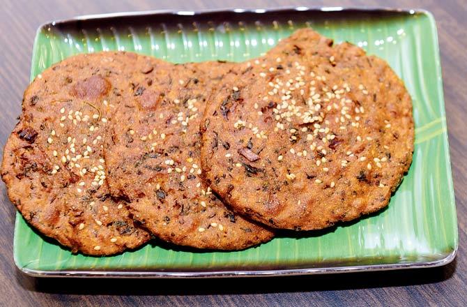Thalipeeth is a multigrain flat bread made with jowar, bajra, besan, atta and rice flour. It is seasoned with condiments like ajwain, salt, and cumin, coriander and red chilli powder. Chopped onion and chillies are added, too, to give the dish a crunchy texture.