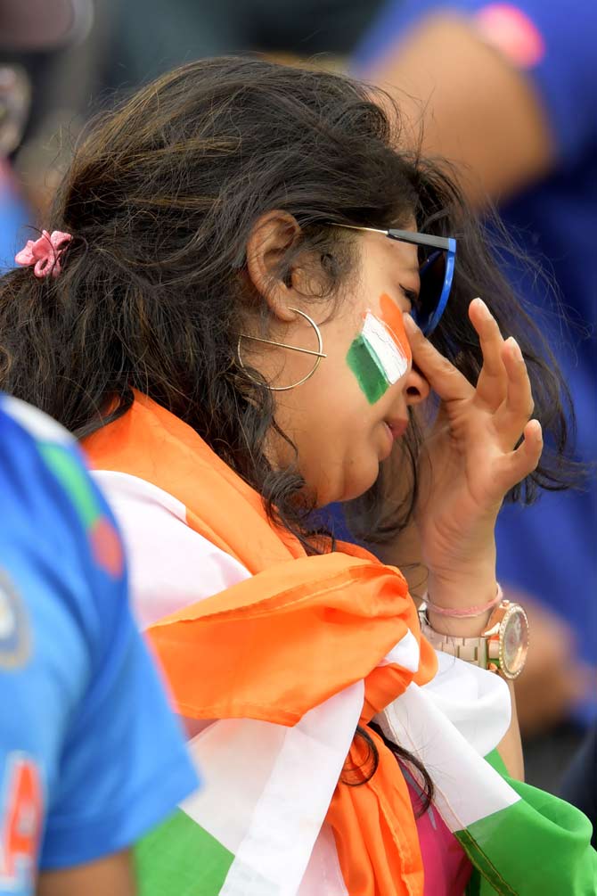 India's fans react at the end of play during the 2019 Cricket World Cup first semi-final between New Zealand and India at Old Trafford in Manchester, northwest England