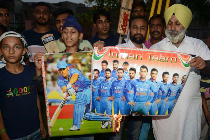 Indian cricket fans burn posters of Indian cricket players during a protest in reaction to the national cricket team poor performance during the first semifinal between India and New Zealand at Old Trafford in Manchester of the 2019 ICC World Cup, in Amritsar June 10, 2019