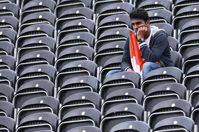India supporters react after losing the 2019 Cricket World Cup first semi-final between New Zealand and India at Old Trafford in Manchester, northwest England