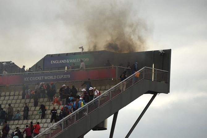A fire breaks out on a stand during the 2019 Cricket World Cup semi-final between New Zealand and India at Old Trafford in Manchester, northwest England