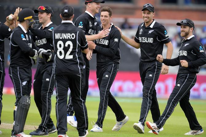 New Zealand's Mitchell Santner (C) celebrates with teammates after dismissing India's Rishabh Pant for 32 during the 2019 Cricket World Cup first semi-final between New Zealand and India at Old Trafford in Manchester, northwest England