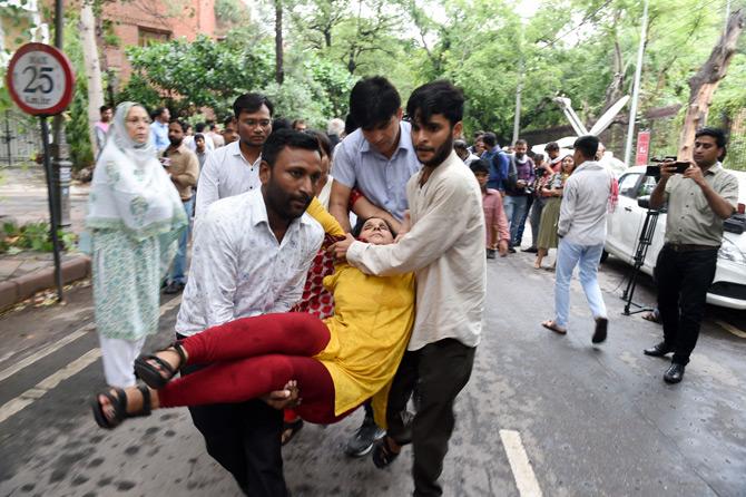 In pic: A Congress supporter is being carried by volunteers after she fainted outside the residence of former Delhi Chief Minister Sheila Dixit in New Delhi.