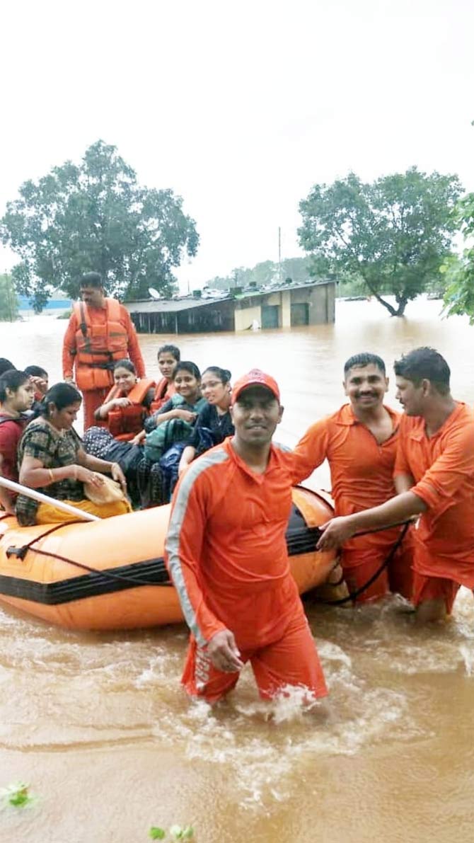 The NDRF team rescued around 500 plus people so far, which include 9 pregnant women. Ambulances with 37 doctors and gynaecologist were deployed during the emergency. 
In pic: NDRF officials still manage to have a smile on their face while bravely performing their duty during the floods. Pic Courtesy/ Indian Navy