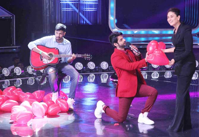 To begin with, Kareena Kapoor Khan had a fun moment with the reality show host Karan Wahi. As we can see in this picture, Karan is on his knees presenting a couple of heart-shaped balloons to the smiling Bebo. Kareena looked stylish in her one-side sleeve black pantsuit.