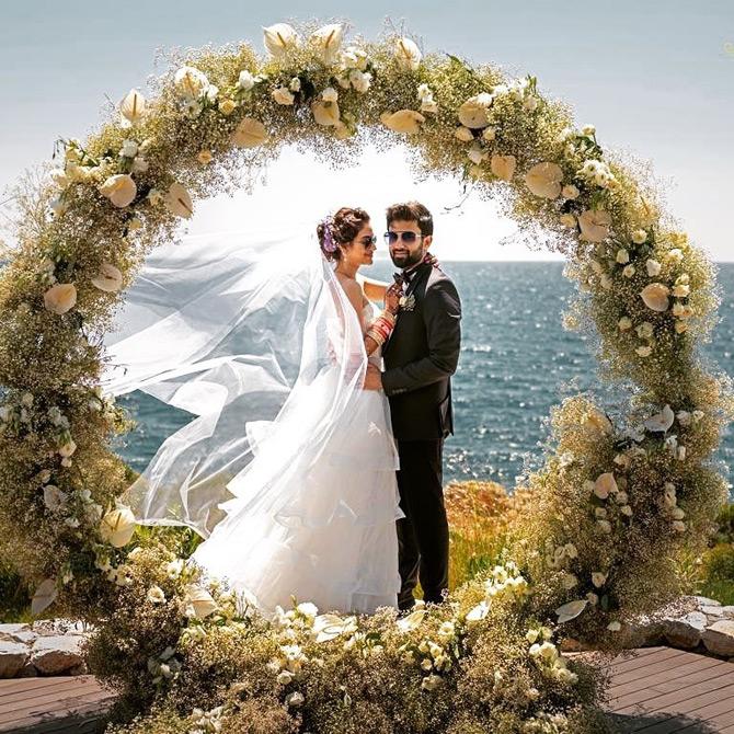 In another picture which went viral after the two tied the knot, the gorgeous bride, Nusrat Jahan looked mesmerising in a white off-shoulder wedding dress paired with a flowing net veil. She completed her look with traditional red bangles and funky black shades. On the other hand, Nusrat's hubby Nikhil Jain was seen donning a classic black suit with a white shirt and a black bow tie.