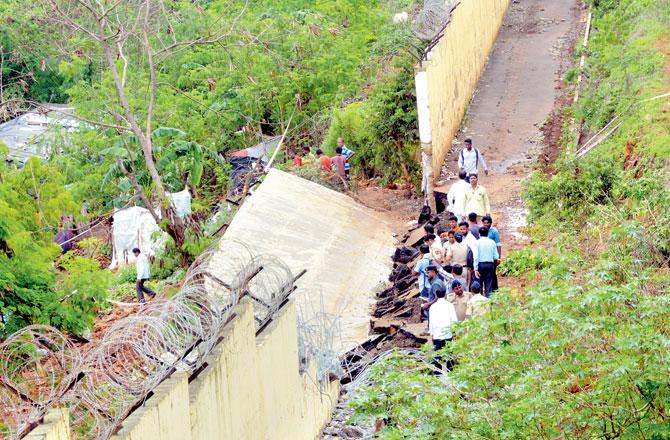 Mumbai Fire Brigade officials bring down parts of the wall that collapsed at Ambedkar Nagar, Malad