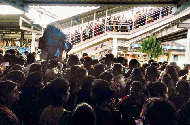 Commuters in hordes try to walk through Thane station awaiting trains
