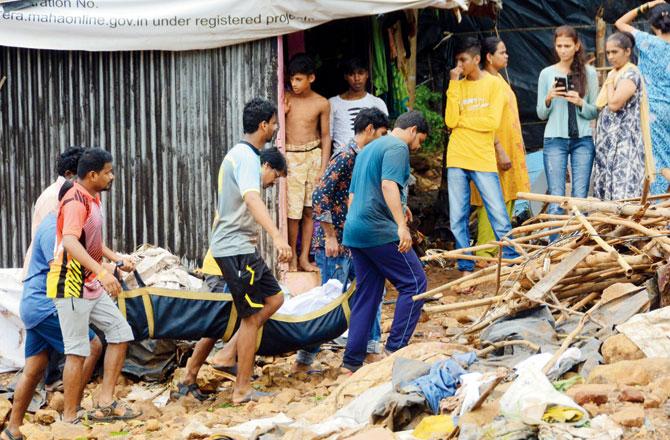 Locals carry away bodies found under the debris for cremation