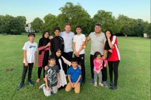 Eoin Morgan plays cricket with an Afghan family in the park