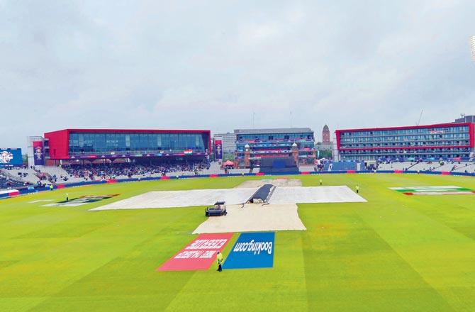 Covers adorn the Old Trafford pitch after rain stops play during the first semi-final between India and New Zealand in Manchester yesterday
