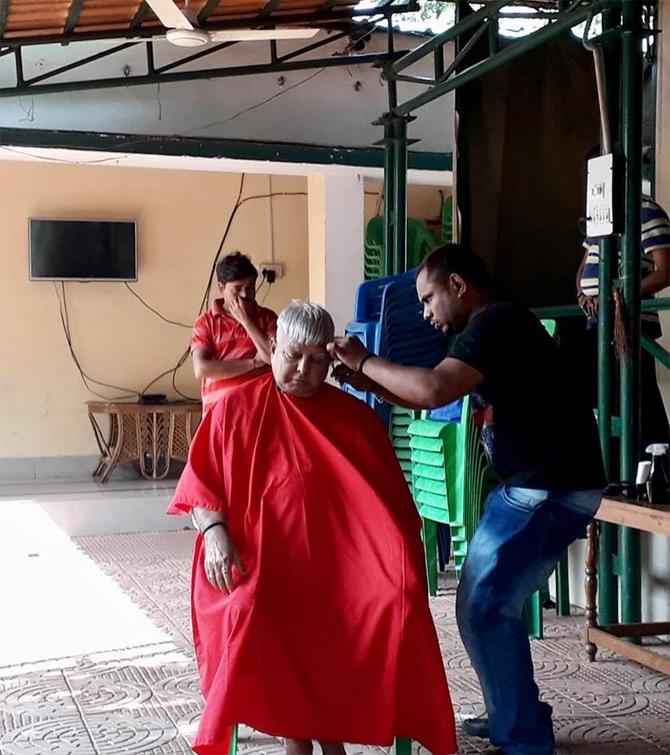 After completing his degree in Bachelor of Laws and a Master in Political Science from B. N. College of Patna University, Lalu Prasad Yadav worked as a clerk in Bihar Veterinary College where his elder brother also worked as a peon.
In pic: Lalu Prasad Yadav gets a haircut on a Sunday. While sharing the picture with his followers Llau wrote: Sunday Day and shaving. This is a pure desi style of a milkman. Very original.