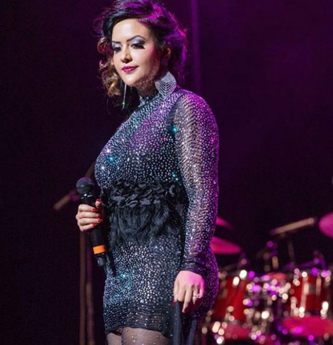 For the musical concert, Amrut Fadnavis was seen donning a black sequinned mini dress with feather detailing and sheer stockings. She completed her with matching earrings and red lipstick.
In pic: Amruta Fadnavis looks like a diva as she is caught in a candid moment during her performance.