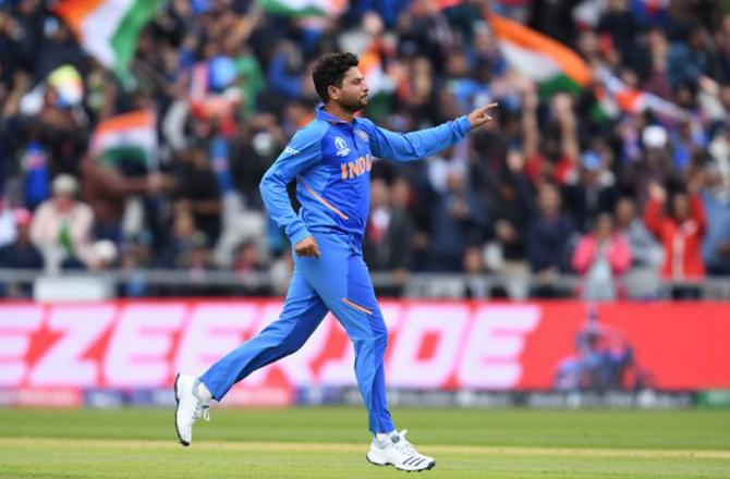 India's Kuldeep Yadav leaps into the air as he celebrates after the dismissal of Pakistan's Babar Azam during the 2019 Cricket World Cup group stage match between India and Pakistan at Old Trafford in Manchester, northwest England, on June 16, 2019.