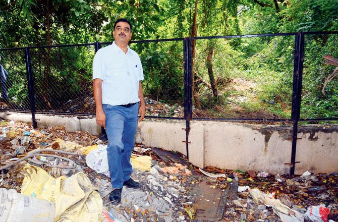 Kishor Kamat pointing to the spot from where water seeps in, making it difficult to even pass by this place. Pics/Satej Shinde
