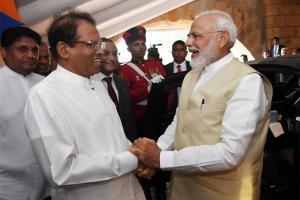 Sri Lanka president holds up umbrella for Modi during rains. See photo