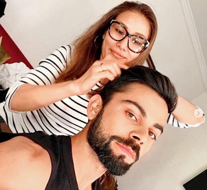 Apeni George (left) with Virat Kohli 