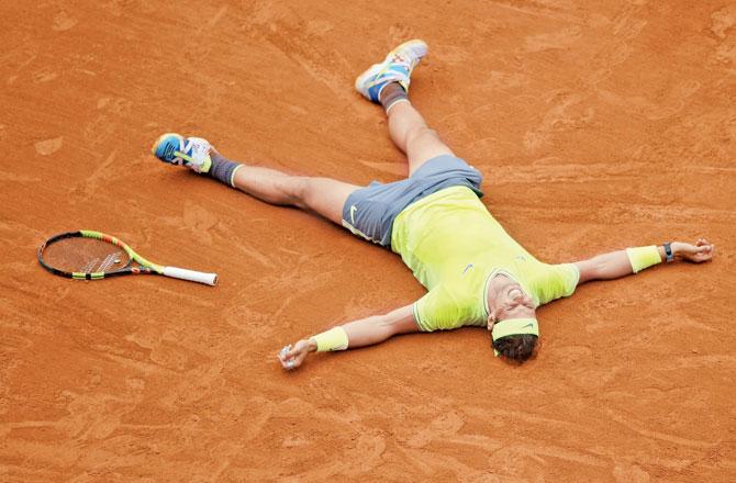 Rafael Nadal falls to the ground after winning the French Open final against Dominic Thiem yesterday
