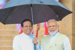 Sri Lanka president holds up umbrella for Modi during rains. See photo