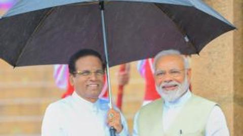 Sri Lanka president holds up umbrella for Modi during rains. See photo