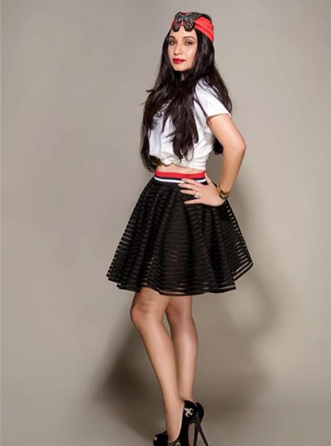 Sheetal Mafatlal looks cute in this white top and black skater skirt paired with a vibrant bow headband. 