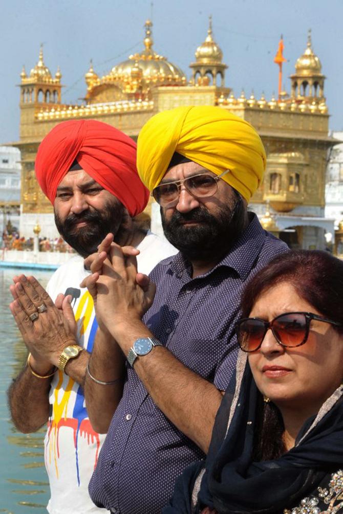 Jaspal Bhatti (C) and Punjabi actors Arvinder Singh Bhatti (L) and Savita Bhatti pose as they pay their respects at the Sikh shrine, The Golden Temple in Amritsar on October 21, 2012. The actors visited the city as part of a promotional tour of their film 'Power Cut' directed by Jaspal Bhatti and produced by Paveljeet Singh.