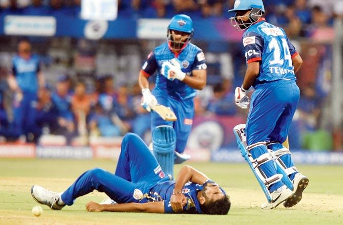 MI pacer Jasprit Bumrah falls while trying to stop the ball in his follow through 