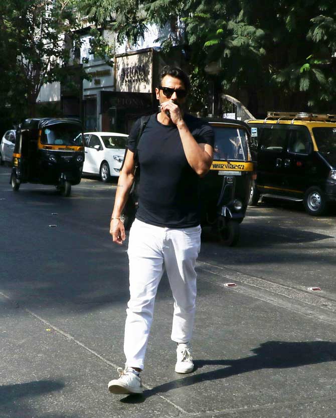 On Tuesday, Arjun Rampal and ex-wife Mehr Jesia were papped on one of the Bandra's thoroughfares. They were spotted entering a bank. The former couple maintained distance with each other. Arjun and Mehr arrived and departed in separate cars. The actor was seen wearing a basic black t-shirt, paired with white pants and sneakers for the outing. All pictures/Yogen Shah