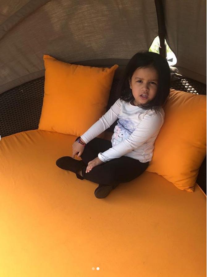 Ziva Dhoni is all smile in this photo where she is seen making herself comfortable on a large sofa.
 