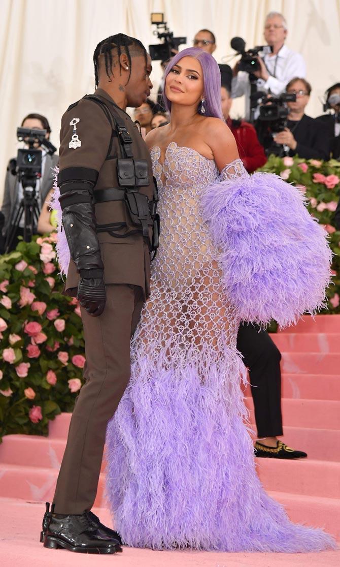 Kylie Jenner arrived with her boyfriend and rapper Travis Scott, who rocked a military-inspired ensemble similar to last year's utility suit with a harness on top. The 21-year-old makeup mogul stunned in a lilac see-through mermaid-picturesque dress, fur stole and perfectly purple wig.