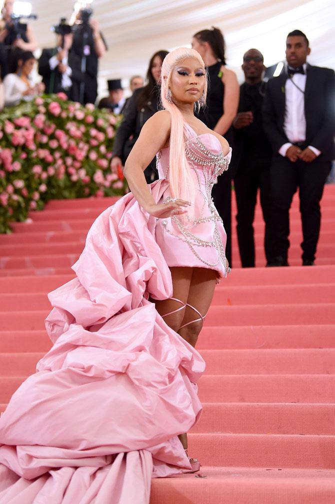 Rapper Nicki Minaj chose to keep it all pink for this year's Met Gala as she strutted on the pink carpet in an embellished Prabal Gurung ensemble. The 'Queen' rapper made a stunning presence at this year's fashion fete in an Atelier Prabal Gurung rococo blush mini featuring a hand-embroidered chandelier crystal hand draped silk taffeta bouillon train. Minaj teamed the look with Brother Vellies custom-made pink satin and Swarovski Crystal strappy sandals that went all the way to mid-thigh and featured a thin stiletto heel. The 36-year-old rapper tied her hair in a long pale pink high ponytail and opted for a bold look with winged eyeliner and lots of blush. She paired the outfit with a series of rings and shimmery statement earrings.