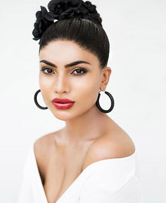 Urvi Shetty looks drop-dead-gorgeous as she dons red lipstick, a white off-shoulder top and her hair tied up in a bun