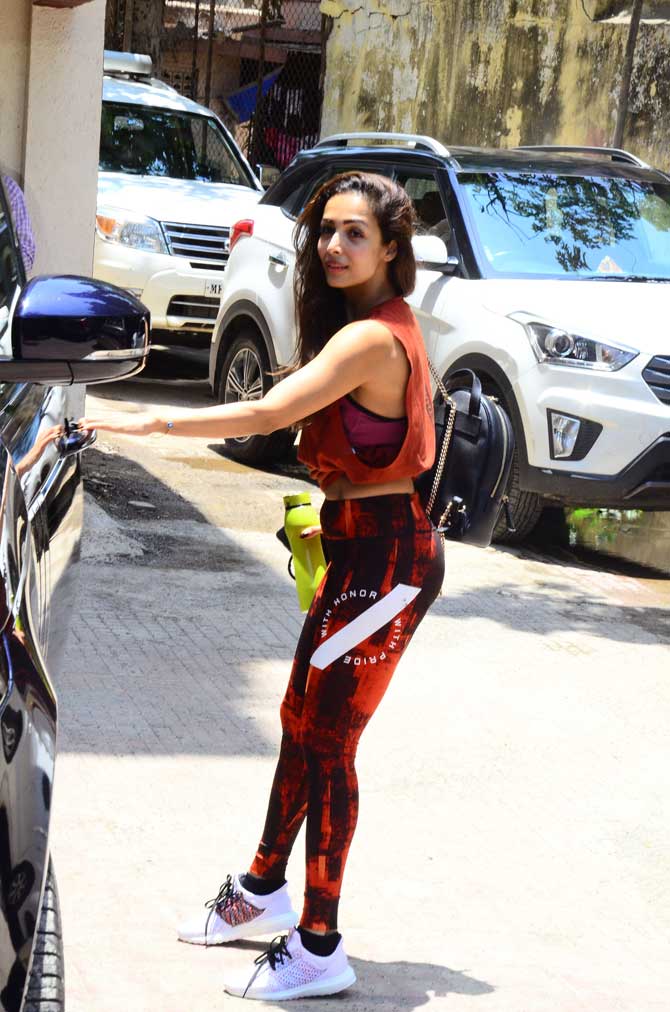 Malaika Arora was spotted at her yoga class in Bandra, Mumbai. The fitness divas wore an orange top and black-orange yoga pants for her workout session. All pictures/Yogen Shah