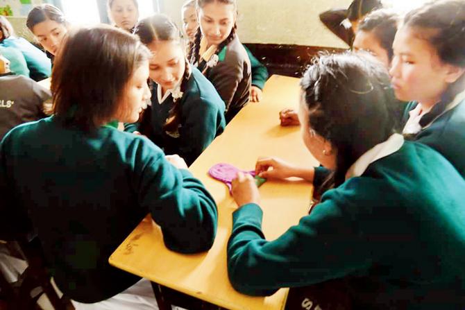 School girls being taught about the right way to dispose sanitary napkins