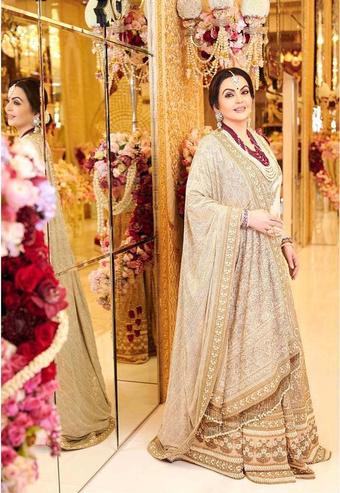 For Akash and Shloka's Mehendi celebration in Mumbai, Nita Ambani opted for a custom-made off-white hand-embroidered and embellished lehenga by designer Sabyasachi. She paired the lehenga with a maroon necklace and accessorised it with a pearl maangtika and floral drop earrings. Picture/Instagram Sabyasachi Mukherjee