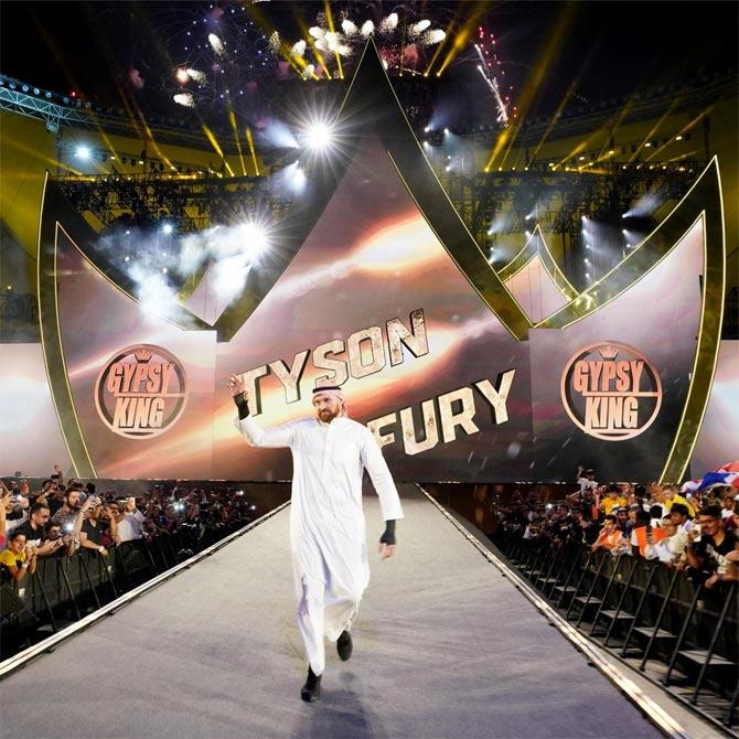 Boxing world heavyweight champion Tyson Fury makes his way to the ring as he gears up to face Braun Strowman in a singles match. Fury was the first heavyweight boxer to do so.